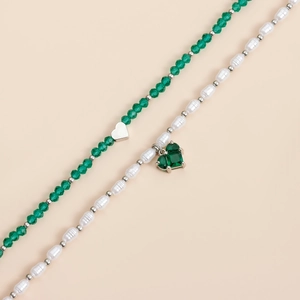 Détail de perles de cristal vertes et perles blanches avec pendentifs cœur en gemme