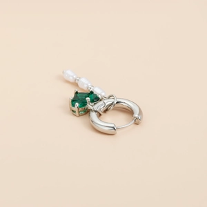 Détail de créole argentée avec pierre de cœur verte et triple pendentifs en perles