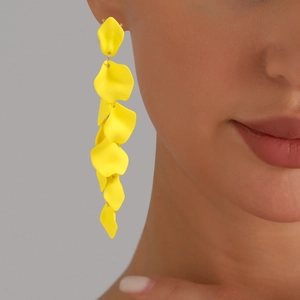 Dettaglio di orecchini a petalo giallo vivace con finitura opaca su una modella