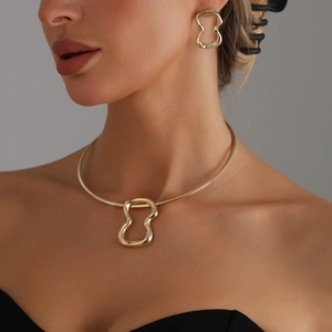 Set choker dorato moderno con pendente a onde irregolari e orecchini coordinati