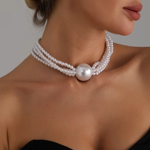 Three-strand layered pearl choker necklace featuring a large round centerpiece pearl