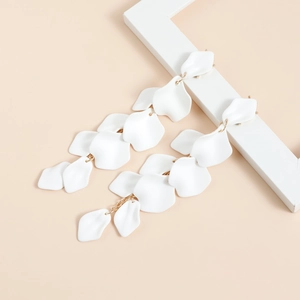 Dettaglio di lunghi orecchini a petalo bianco con elegante catena dorata