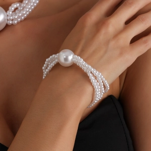 Elegant multi-layer pearl necklace and bracelet set featuring a large statement pearl bead