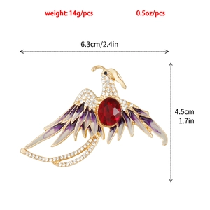 Détail d'une broche oiseau avec ailes en émail violet et une pierre précieuse rouge