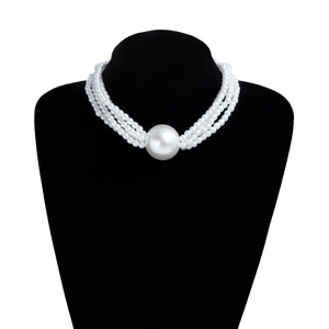 Detailed close-up of triple-layered pearl necklace with a large central pearl on a bust