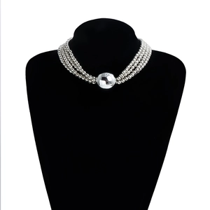 Macro shot of tiered silver bead necklace featuring a large polished spherical pendant