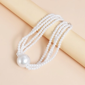 Macro shot of layered pearl choker with large spherical center bead and five strands