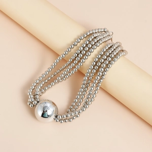Close-up of a silver multilayer beaded necklace featuring a large polished spherical pendant