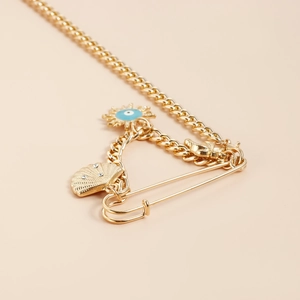 Broche épingle dorée avec pendentifs œil bleu soleil et charm en forme de coquillage