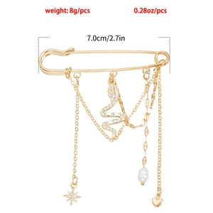 Détail d'une broche épingle vintage dorée avec pendentifs serpent, cœur et étoile en 7cm