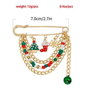 Detailed close-up of a Christmas safety pin brooch with charms, bells, and holiday beads