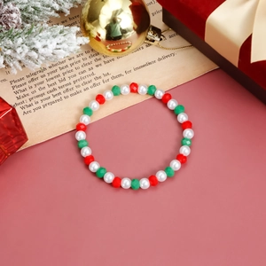 Set di bracciali natalizi con cristalli rossi verdi e perle bianche su sfondo rosa