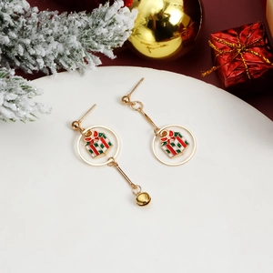 Detalle de pendientes navideños asimétricos con caja de regalo y campana dorada