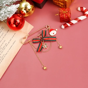 Detailed view of Christmas brooch with Santa charm, red bow, and long gold tassels