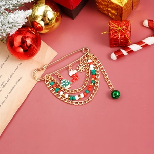 Christmas safety pin brooch with charms of tree and bells on festive background
