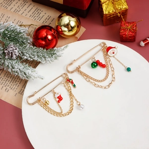 Detail of Christmas brooches with Santa and stocking charms on layered gold chains