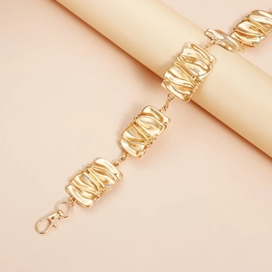 Detail of champagne gold waist chain with ripple textured rectangular metal links