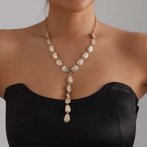 Gold Y-shaped leaf necklace with hammered texture shown on model in a long drop design