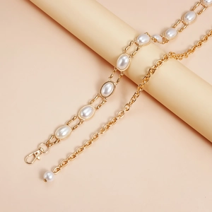 Detailed view of oval pearl insets on a gold-tone geometric chain link waist belt