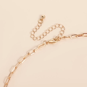 Close-up of gold irregular leaf Y necklace with lobster clasp and adjustable extender chain