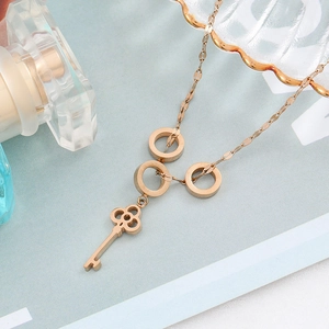 Roségouden titanium stalen ketting met drie ringen en holle sleutelhanger op blauw