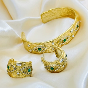 Vintage gold evil eye jewelry set with textured open bracelet and C-shaped earrings