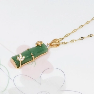 Detailed macro view of the bamboo joint pendant with green stone and gold leaves