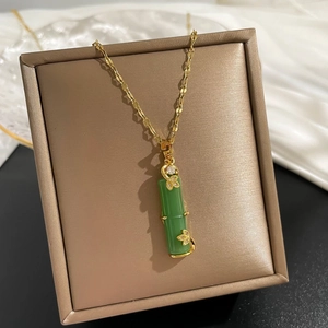 Detailed close-up of green bamboo pendant with gold butterfly and zircon inlay