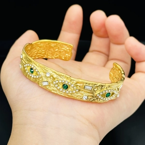 Retro golden evil eye cuff bracelet with green gemstone and hammered texture