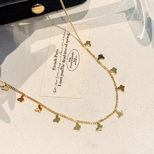 Elegante goldene Schmetterlingskette mit mehreren Anhängern an minimalistischer Kette