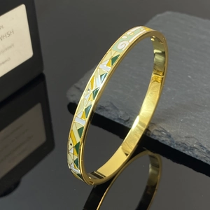 Brazalete vintage de acero de titanio dorado con patrones geométricos de esmalte