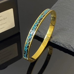 Brazalete vintage de acero titanio dorado con patrones de esmalte azul cielo y negro