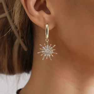 Exquisite Goldohrringe mit Sonnenblumen-Motiv und weißen Strasssteinen am Modell