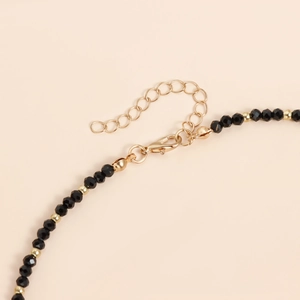 Detail von verstellbarem Gold-Karabinerverschluss und schwarzen Perlen auf Sonnenblumen-Kette
