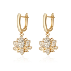 Détail de boucles d'oreilles lotus dorées serties de zircons blancs étincelants