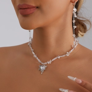 Irregular faux stone necklace set with hollow heart wing pendant on model