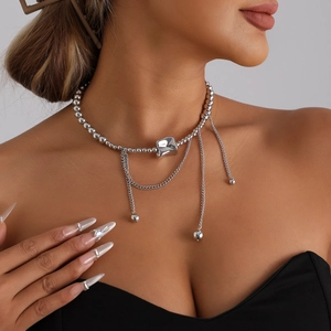 Silver bead necklace with irregular square charm and tassel chains on a model