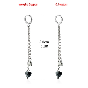 Detail van lange kwastjes oorbellen met metalen hartjes en 8 cm lengte weergave
