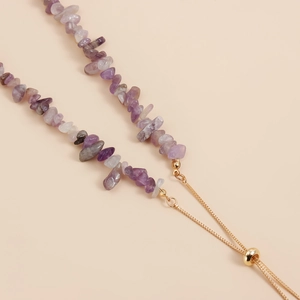 Macro detail van paarse amethist steen ketting met verstelbare goudkleurige sluiting