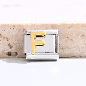 Macro view of gold letter F charm for Italian modular bracelet in polished stainless steel