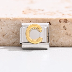Macro shot of Italian charm bracelet link with gold letter C on silver stainless steel