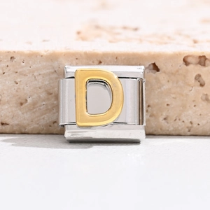 Macro shot of gold letter D on polished stainless steel Italian modular charm link