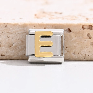 Macro view of stainless steel Italian charm link with gold embossed letter E module