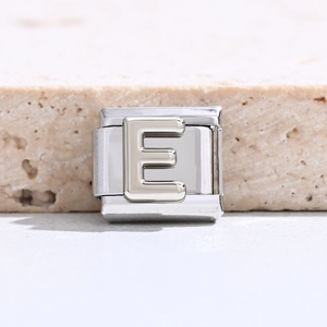 Detailansicht eines silbernen Edelstahl-Armbandglieds mit dem Buchstaben E für DIY-Schmuck