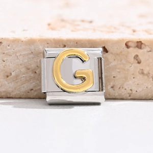 Detail of DIY Italian charm bracelet showing a gold-plated letter G on stainless steel link