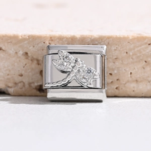 Makro-Detail des italienischen Charm-Glieds mit silberner Libelle und funkelnden Zirkonia