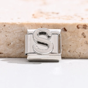 Makro-Detail eines italienischen Modul-Charms mit poliertem silbernem Buchstaben S aus Edelstahl