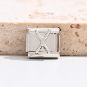 Makrofoto eines silbernen Edelstahl-Armbandglieds mit einem polierten Buchstaben X