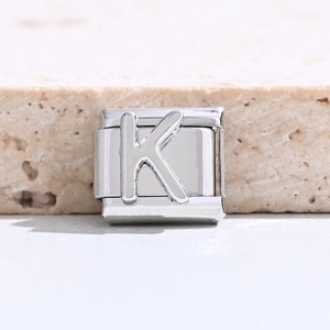 Makroaufnahme von silbernem italienischem Modul-Charm aus Edelstahl mit 3D-Buchstabe K
