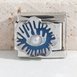 Détail macro du charm en acier inoxydable de style italien avec fleur bleue et perle